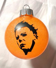 an orange ornament with a drawing of a man's face on it