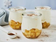 three jars filled with food sitting on top of a white table next to a spoon