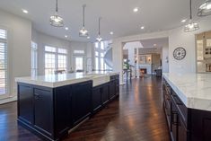 a large kitchen with an island in the middle and lots of windows on both sides