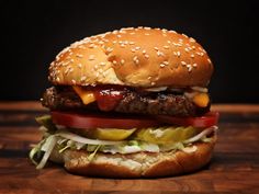 a hamburger sitting on top of a wooden table