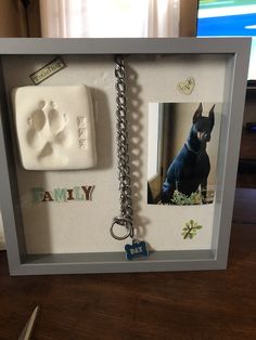 a photo frame with a dog keychain and magnets attached to it, sitting on a table