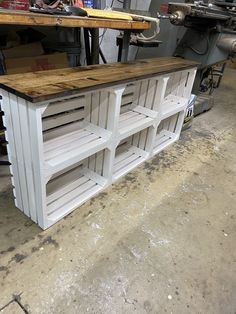 an unfinished kitchen island made out of pallets and wooden planks in a shop