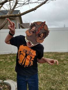 a young boy wearing a t - shirt with an animal mask on