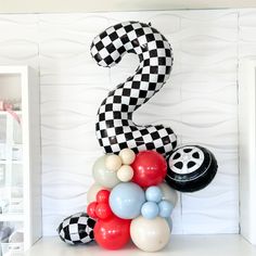 the number two is made out of balloons and black and white checkerboard numbers