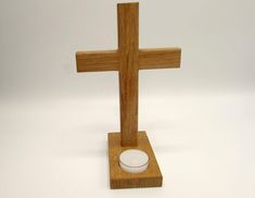 a small wooden cross with a candle holder