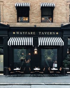 the outside of a restaurant with black and white awnings on it's windows