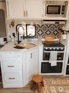 a kitchen with an oven, microwave and stool