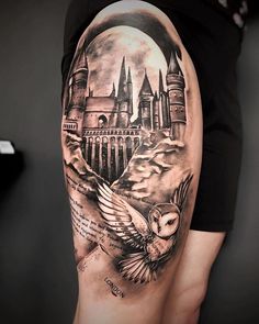 a woman's thigh with an owl and castle tattoo on it