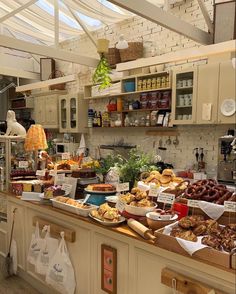 a kitchen filled with lots of food on top of wooden counter tops under a glass ceiling