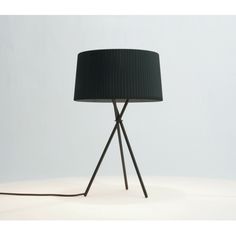 a lamp that is on top of a white surface with a black lampshade