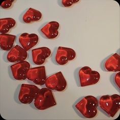 red hearts are scattered on a white surface