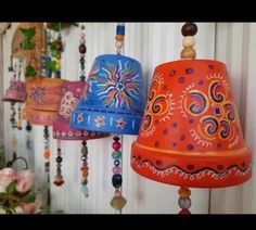 three colorful bells hanging from the side of a wall