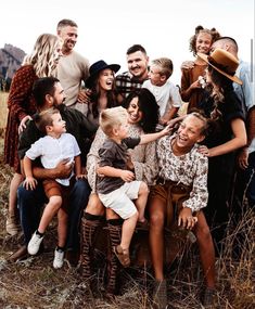 a large group of people are posing for a photo in the grass with one child on his lap