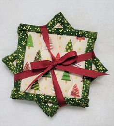 four christmas tree napkins tied together with red ribbon