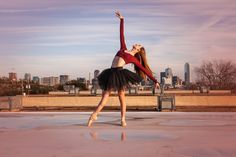 a woman in a red top and black tutu is doing a ballet move on the ice