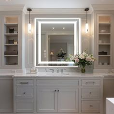 a bathroom with two sinks and a large mirror over the sink, surrounded by built - in shelving