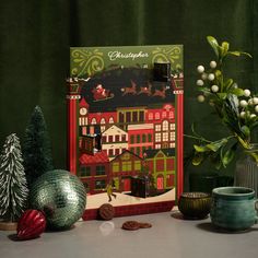 there is a christmas card on the table next to some ornaments and other things in front of it