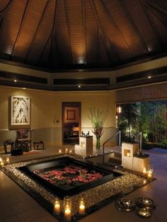 an indoor spa with candles lit around it