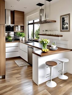 a modern kitchen with white cabinets and wood flooring is pictured in this image, there are two stools at the center of the island