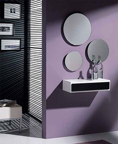 a bathroom with purple walls and mirrors on the wall