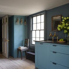 a kitchen with blue walls and wooden floors