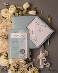 wedding stationery and flowers on grey background with silver button, white rose boutonniere