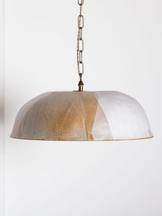 a light that is hanging from a chain on a wall in a room with white walls