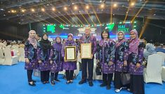 several women in hijabs are holding an award