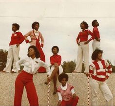 a group of women standing next to each other on top of a cement wall with candy canes in front of them