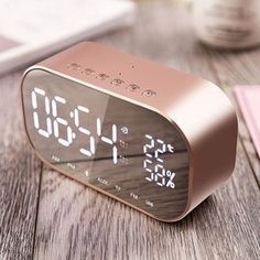 an alarm clock sitting on top of a wooden table