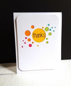 a thank card with the word thanks written in orange, green and blue dots on it