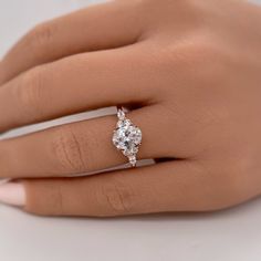 a woman's hand with a diamond ring on top of her finger and an engagement band