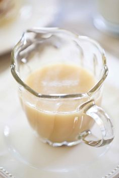 a glass cup filled with liquid on top of a white plate