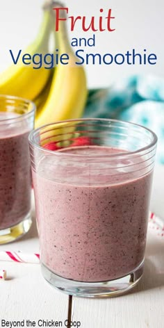 two glasses filled with fruit and veggie smoothie on top of a table