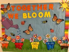 a bulletin board with flowers, butterflies and watering can in the background that says together we bloom