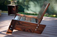 a wooden bench sitting on top of a wooden deck next to a planter and potted tree