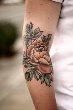 a woman with a flower tattoo on her arm