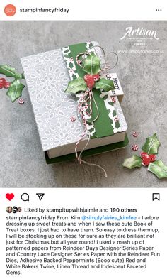 an open book with holly decorations on it