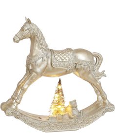 a white horse figurine sitting next to a christmas tree