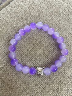 This 8mm, handmade, purple and clear crackled beads, beaded bracelet is super cute! it is  finished with an adorable silver tone cat charm in the center. This is made with clear stretch cord and is 7 inches in length but I can adjust it if needed, just request at checkout!  This is an absolutely gorgeous bracelet and would be a great birthday present, anniversary present, Valentine's Day  present, Christmas present; or graduation gift. Like what you see? View more at: https://www.etsy.com/shop/S Cute Purple Hypoallergenic Bracelets, Adjustable Nickel-free Purple Charm Bracelet, Casual Purple Hypoallergenic Jewelry, Charm Bead Bracelet, Pet Jewelry, Valentines Day Presents, Cat Mom Gifts, Cat Charm, Jewelry Beaded