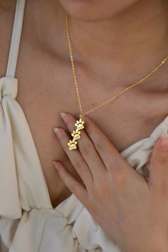 a woman wearing a gold necklace with flowers on the front and back of her chest