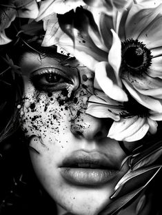 a black and white photo of a woman with flowers on her face