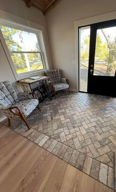 a living room with two chairs and a door that leads to the outside patio area