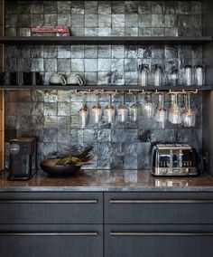 the kitchen counter is covered with glass jars and silver toaster on it's shelf