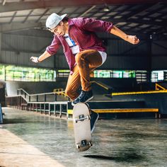 a skateboarder is jumping in the air with his board at an indoor facility