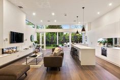 a living room filled with furniture and a flat screen tv on top of a wooden floor