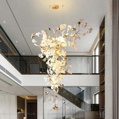 a large chandelier hanging from the ceiling in a living room next to a staircase