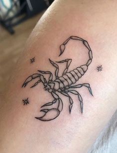 a scorpion tattoo on the back of a woman's arm, with stars around it