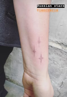 a person with a small star tattoo on their left arm and the word, russian stars