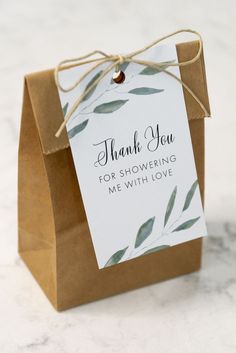 a brown paper bag with a thank you tag attached to the front and side of it that says, thank you for showering me with love